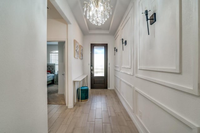 doorway featuring a notable chandelier and light hardwood / wood-style floors