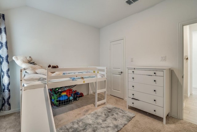 bedroom featuring light carpet and lofted ceiling