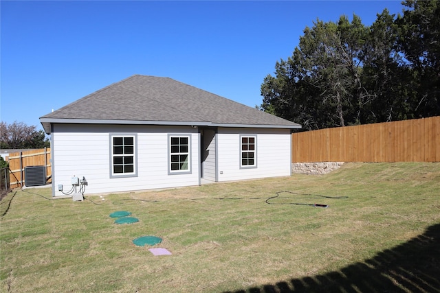 rear view of house featuring a lawn and central air condition unit