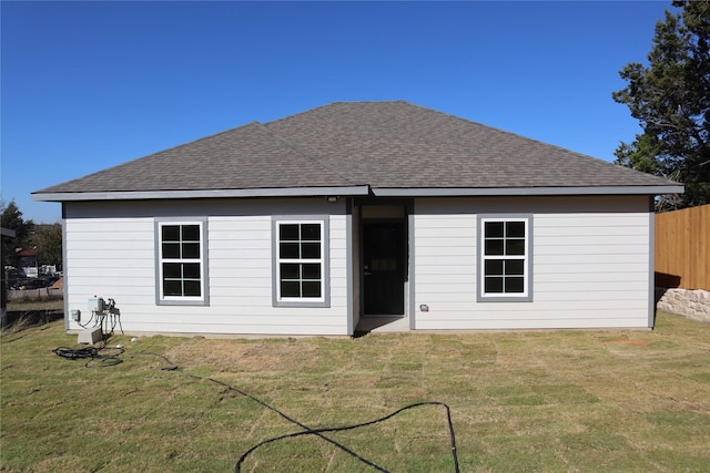 rear view of house featuring a yard