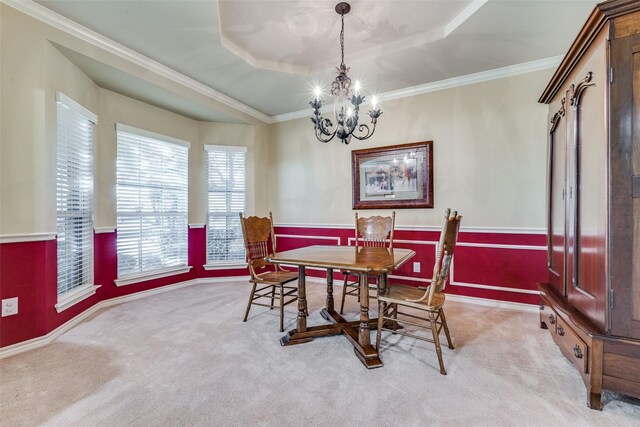 carpeted dining space with a raised ceiling, crown molding, and a notable chandelier