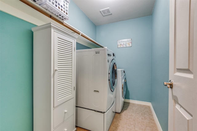 laundry area featuring washer and clothes dryer and light tile patterned flooring