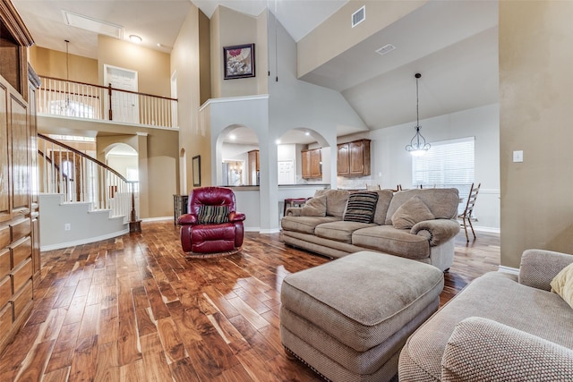 living room featuring hardwood / wood-style floors, high vaulted ceiling, and a chandelier