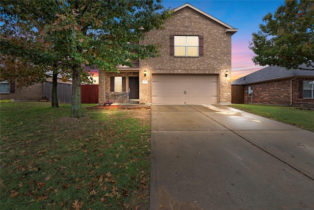 front of property with a yard and a garage