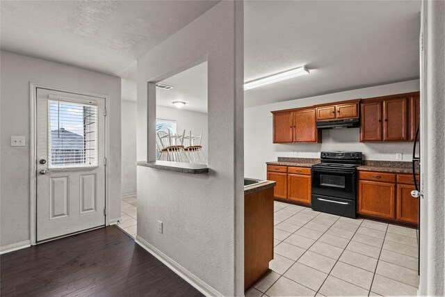 kitchen with light hardwood / wood-style flooring and black / electric stove