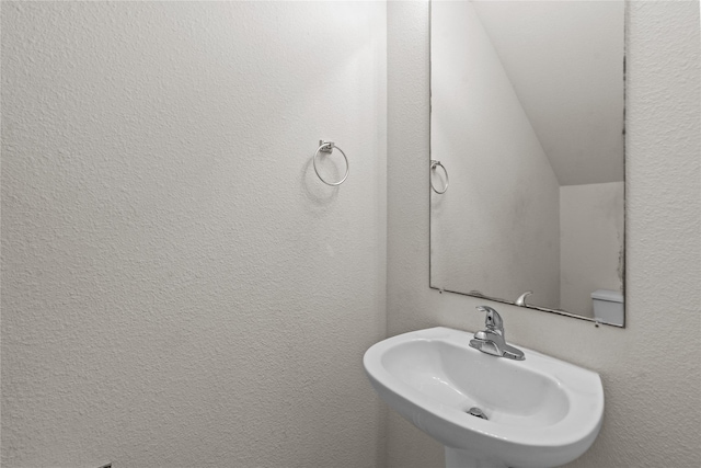 bathroom with lofted ceiling and sink