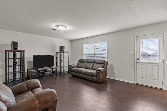 living room featuring dark hardwood / wood-style flooring and a textured ceiling