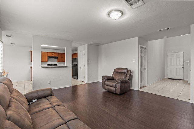 living room featuring a textured ceiling and light hardwood / wood-style flooring