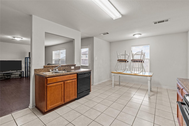 kitchen featuring dishwasher, sink, stainless steel stove, a textured ceiling, and light hardwood / wood-style floors