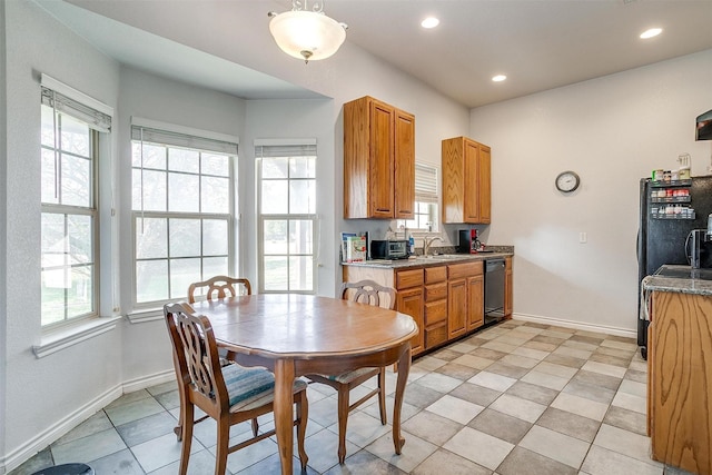 dining space with sink, light tile patterned floors, and a healthy amount of sunlight