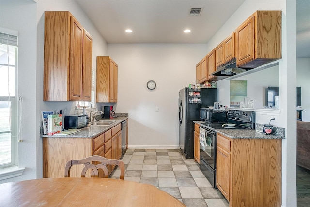 kitchen with light stone countertops, sink, and black appliances