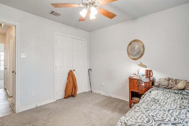 carpeted bedroom with ceiling fan and a closet