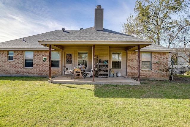 rear view of house featuring a lawn and a patio area