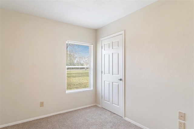 unfurnished bedroom with connected bathroom, light colored carpet, multiple windows, and ceiling fan