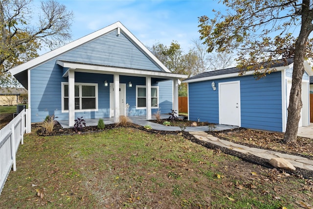 view of front of property with a porch, an outbuilding, and a front yard