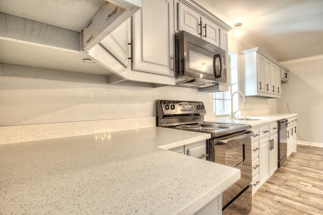 kitchen with black appliances, light hardwood / wood-style floors, crown molding, and sink