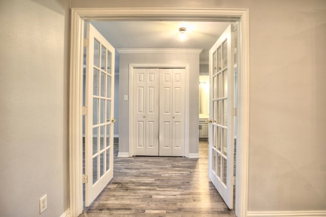 hall featuring hardwood / wood-style flooring, ornamental molding, and french doors