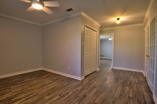 empty room featuring ceiling fan, dark hardwood / wood-style flooring, and crown molding