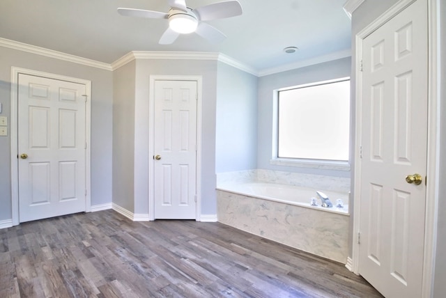 bathroom featuring ceiling fan, a relaxing tiled tub, ornamental molding, and hardwood / wood-style flooring