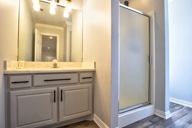 bathroom with a shower with door, vanity, ornamental molding, and hardwood / wood-style flooring