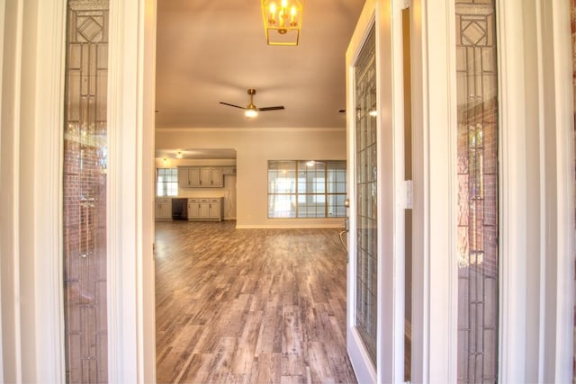 hall with wood-type flooring and ornamental molding