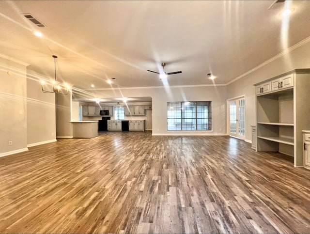 unfurnished living room with ceiling fan with notable chandelier, dark hardwood / wood-style flooring, and ornamental molding