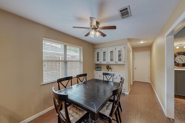 dining space with light hardwood / wood-style floors and ceiling fan