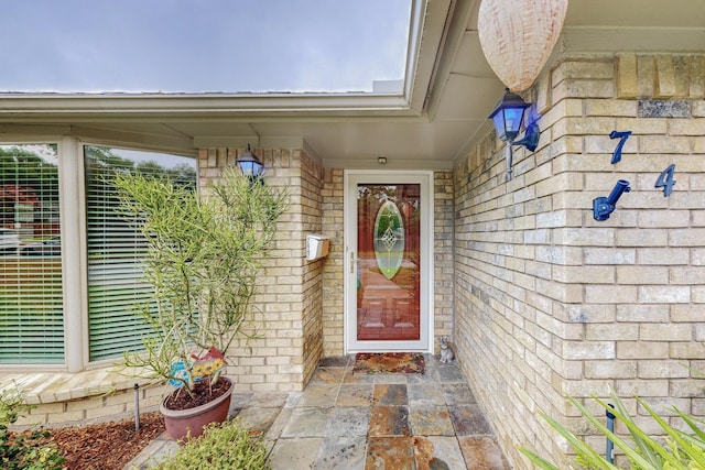 doorway to property featuring brick siding