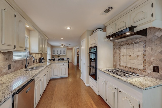 kitchen with backsplash, ceiling fan, light hardwood / wood-style floors, and stainless steel appliances