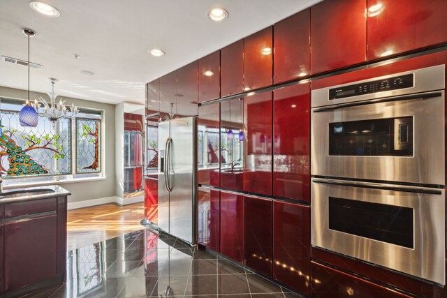 kitchen featuring appliances with stainless steel finishes, sink, and a notable chandelier