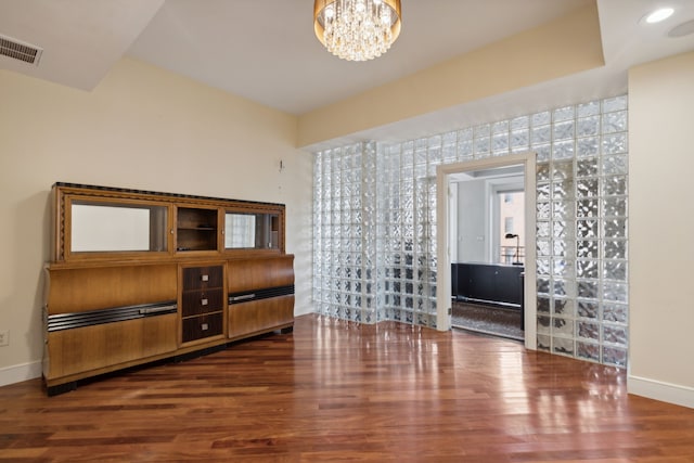 living room with dark wood-type flooring and a notable chandelier