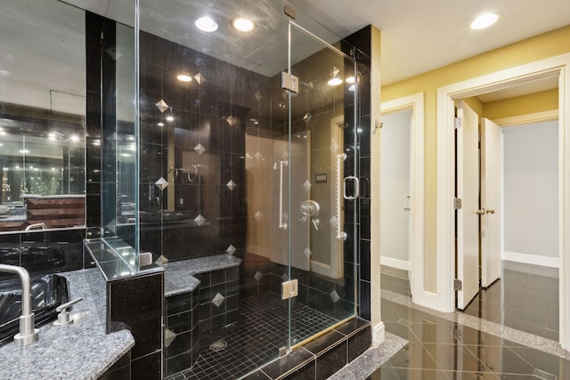 bathroom with a shower with shower door and tile patterned flooring