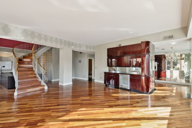 kitchen with wine cooler, decorative light fixtures, a chandelier, and hardwood / wood-style floors