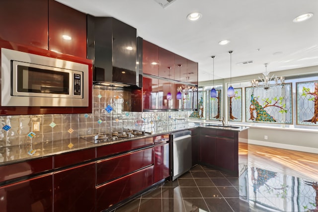 kitchen featuring sink, backsplash, stainless steel appliances, decorative light fixtures, and wall chimney exhaust hood