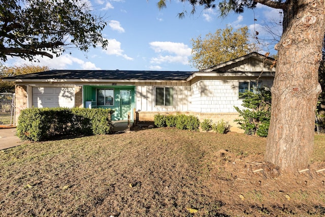 ranch-style home featuring a garage and a front lawn