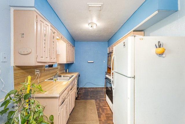 kitchen with dark parquet floors, white appliances, and sink