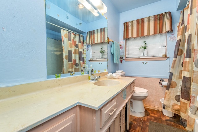 bathroom with vanity, curtained shower, toilet, and parquet floors