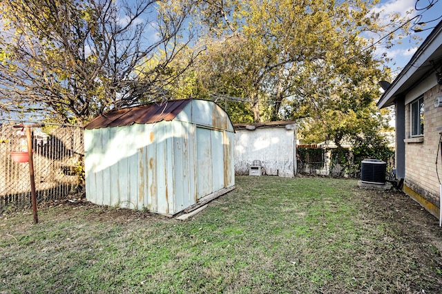 view of outdoor structure featuring a yard and central AC