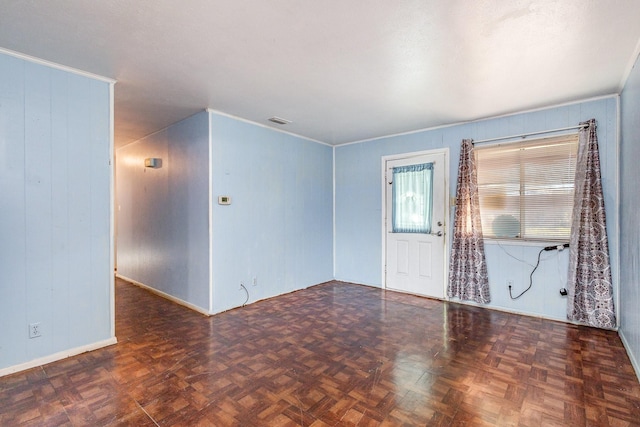 empty room featuring dark parquet floors and wooden walls