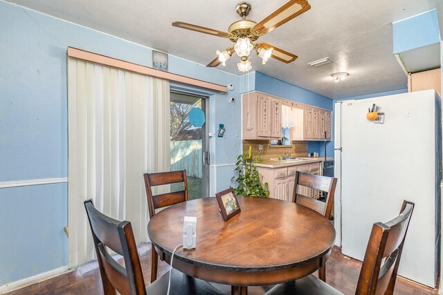 dining area with hardwood / wood-style flooring, ceiling fan, wood walls, and a textured ceiling