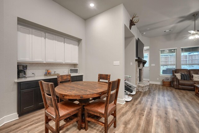 living room featuring ceiling fan, light hardwood / wood-style floors, and vaulted ceiling