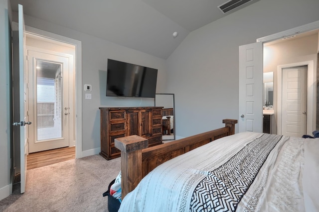 carpeted bedroom with multiple windows, ensuite bathroom, and lofted ceiling