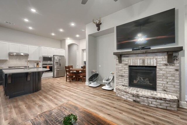 kitchen with a center island, white cabinets, light hardwood / wood-style flooring, and appliances with stainless steel finishes