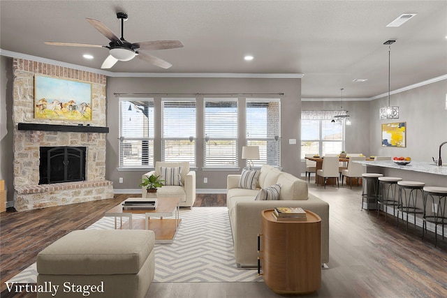 living area featuring a healthy amount of sunlight, wood finished floors, and ornamental molding
