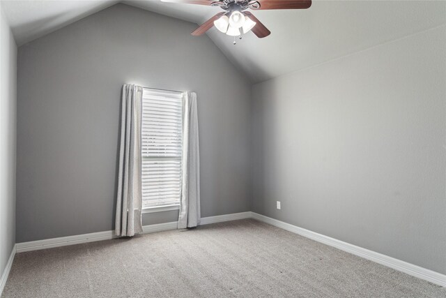 carpeted empty room with lofted ceiling, baseboards, and ceiling fan