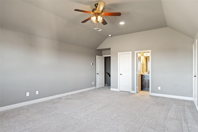 unfurnished bedroom with light colored carpet, vaulted ceiling, ensuite bath, and ceiling fan