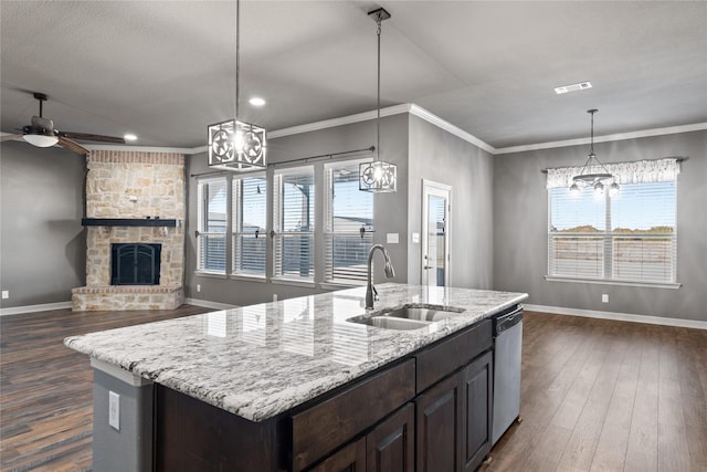 kitchen with dark wood-style flooring, ornamental molding, a sink, stainless steel dishwasher, and ceiling fan with notable chandelier