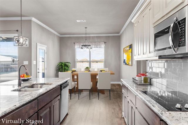 kitchen featuring visible vents, light wood finished floors, a sink, stainless steel appliances, and a chandelier