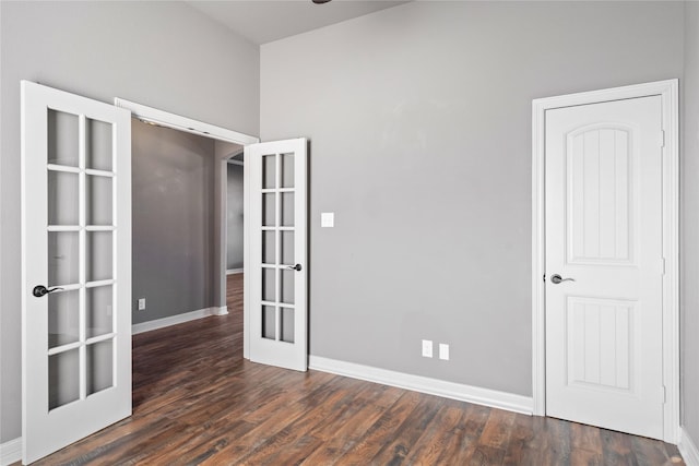 unfurnished room featuring french doors, baseboards, and wood finished floors