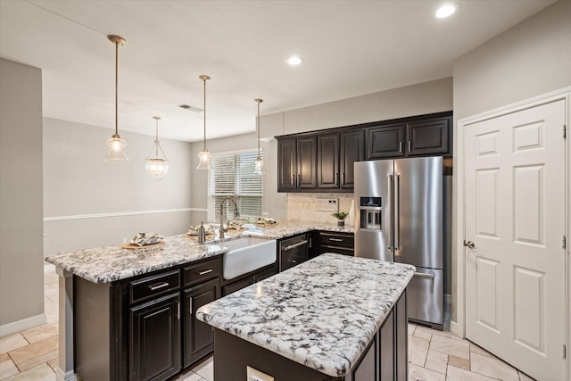 kitchen with sink, a kitchen island, hanging light fixtures, and appliances with stainless steel finishes